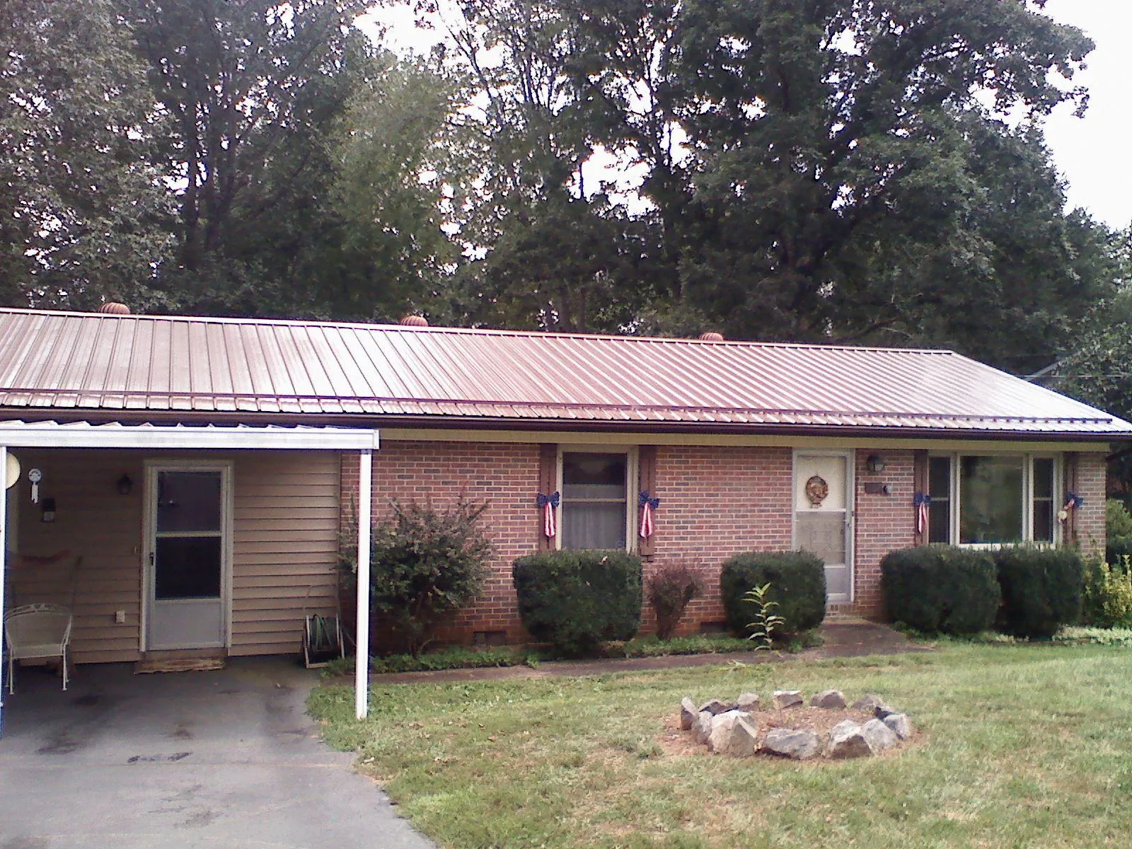 Bronze metal roof and carport on a brick ranch home — Roof Repair work by our crew in Cromwell